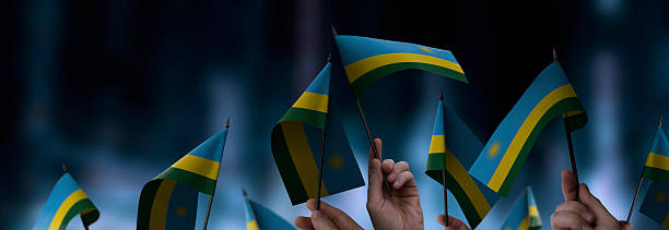Rwanda flags in their hands on a blurred urban background. The photo illustration was created without the use of artificial intelligence, only using Photoshop.