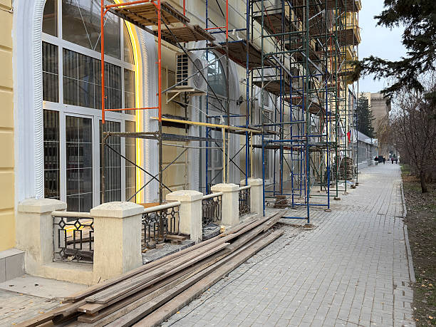 Construction work is ongoing on a building with scaffolding on the street.