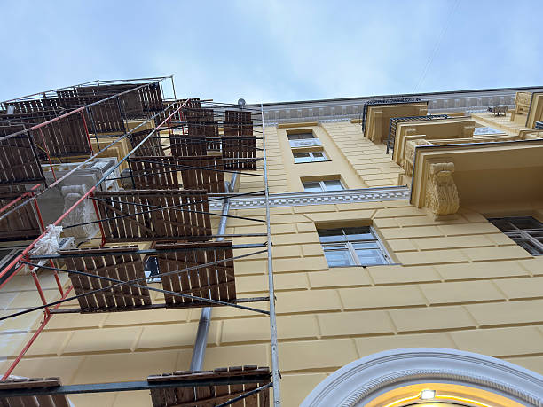 istock Scaffolding surrounds a yellow building while workers perform repairs from above 2253441662