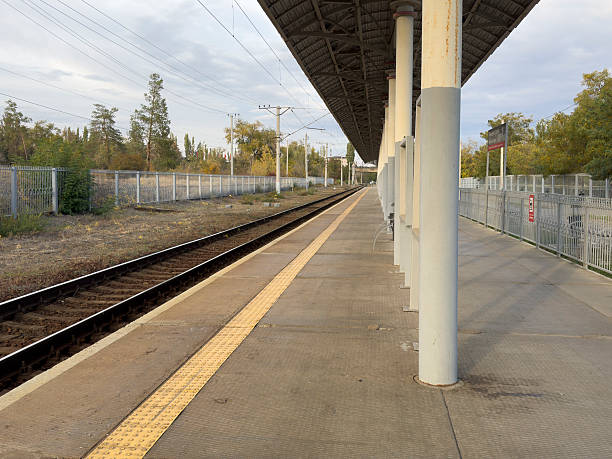istock People are absent from the train station platform under a cloudy sky 2253442699