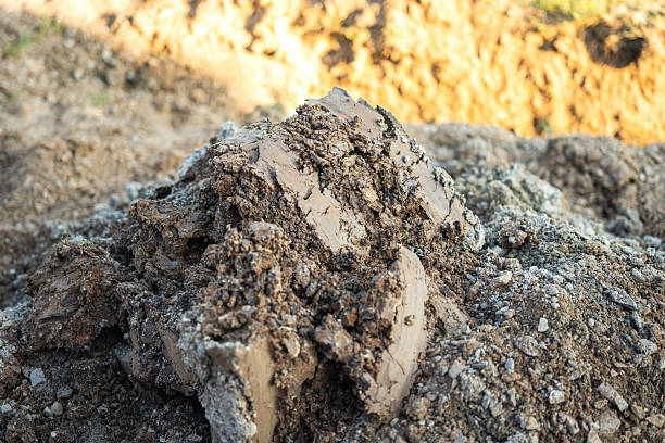 Soil bulk at that excavated at construction building site. Industrial working place, close-up and selective focus.