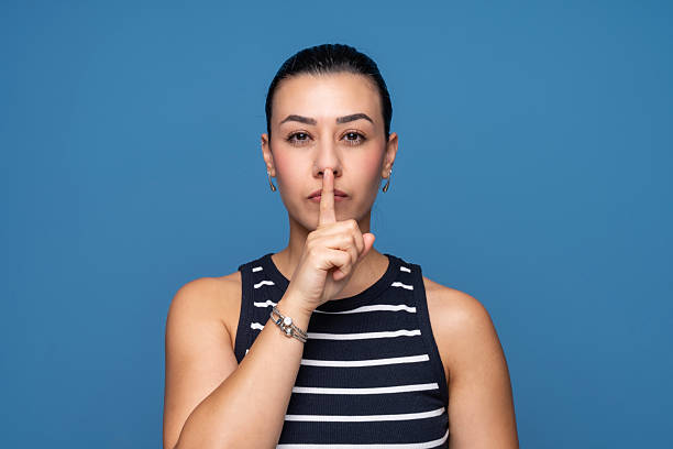 istock Woman making a silence gesture with finger on lips 2253444648
