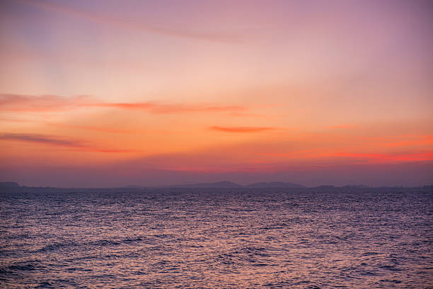 Tranquil coastal sunrise with warm hues and gentle waves.