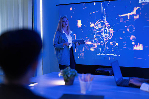 istock Business presentation on technology trends with a female speaker and digital graphics in a modern conference room 2253448112