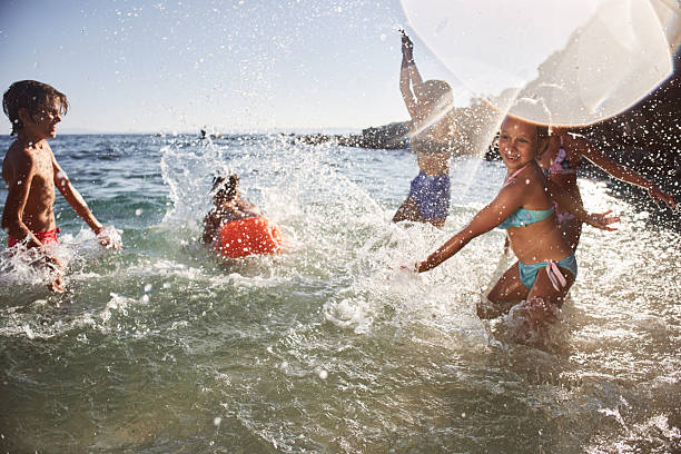 Happy children are enjoying water games in the ocean on a bright sunny day