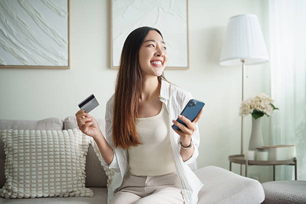 istock Happy female making a mobile payment using a credit card and smartphone app. 2253449655