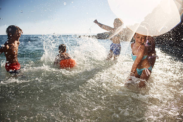 Kids splashing water and having fun on the beach during a summer day