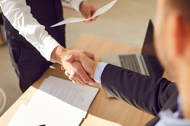 istock Two male business partners shaking hands after successful agreements at work. 2253450085