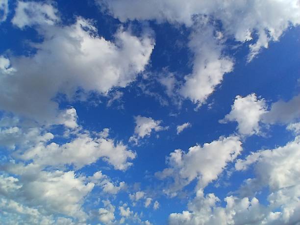 White clouds, blue sky, and sun at midday