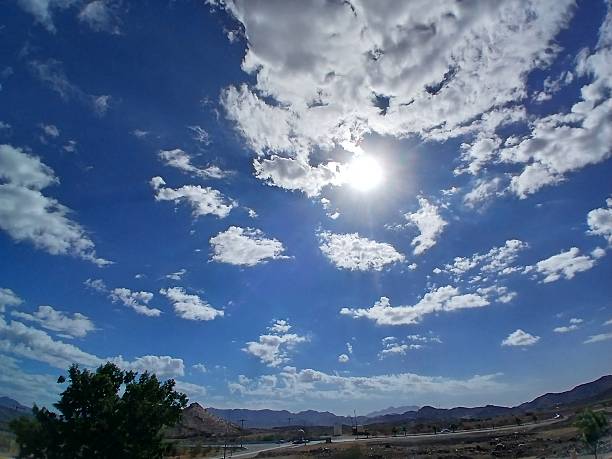 White clouds, blue sky, and sun at midday