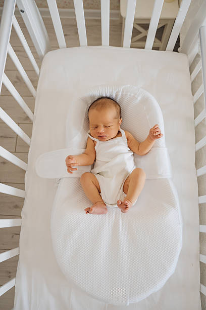 istock Baby sleeps peacefully in a crib during daytime hours 2253454310