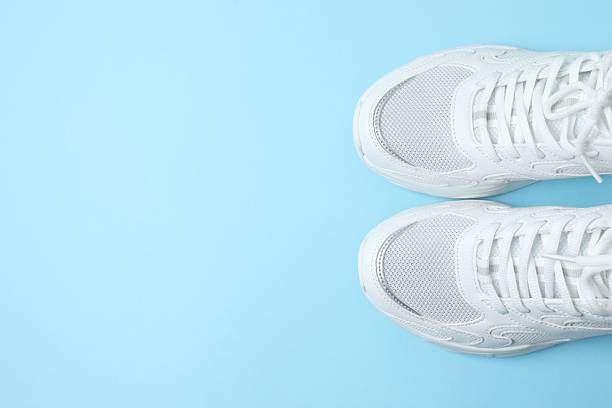 istock White sneakers on a blue background 2253454655