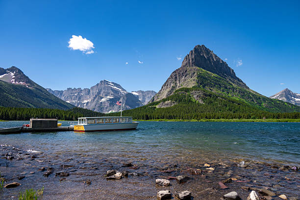 istock Boat on Alpine Lake Beneath Dramatic Mountain Peaks 2253458152