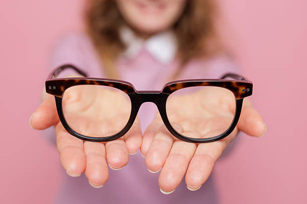 Close up of tortoise eyeglasses in open palms with blurred woman for optical retail and vision correction advertising