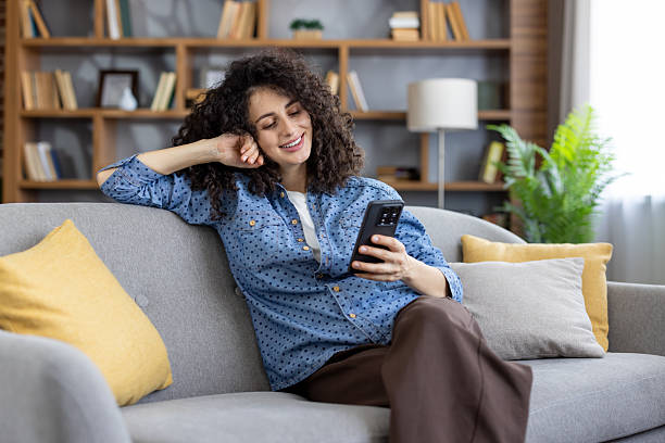 istock Woman relaxing on couch using smartphone for communication 2253462169