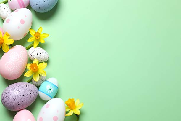 istock Happy Easter. Colorful eggs and yellow flowers on color background, space for text or advertising 2253462422