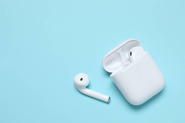 istock Wireless ear phones with a white box on color background 2253462443