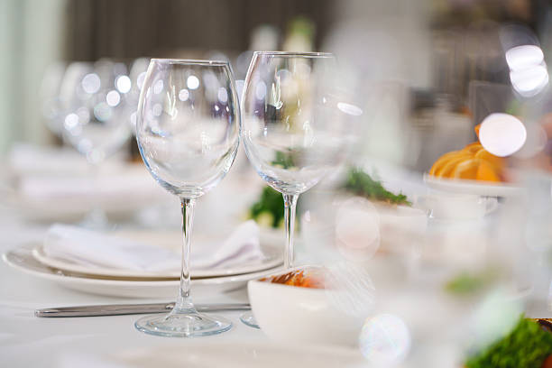 A beautifully arranged dining table features sparkling glasses and gourmet dishes ready for a festive gathering, set in a warm and inviting atmosphere.
