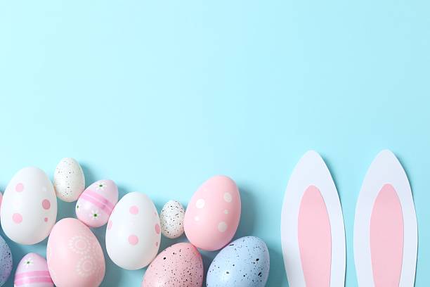 istock Happy Easter. Colorful eggs with bunny ears on color background, space for text or advertising 2253462853