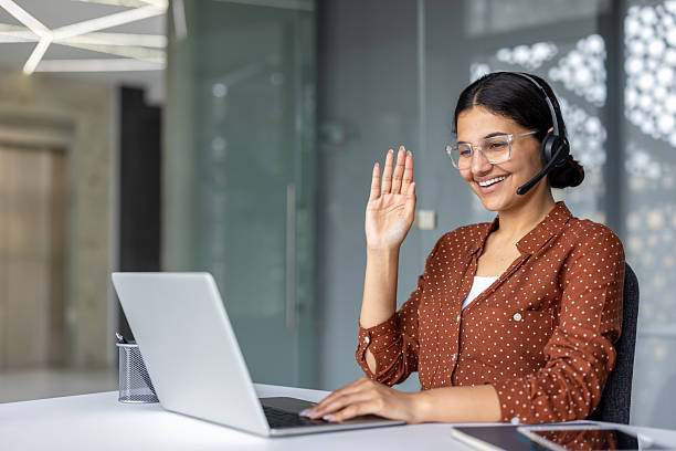istock Young woman having online video call using laptop and headset 2253463464
