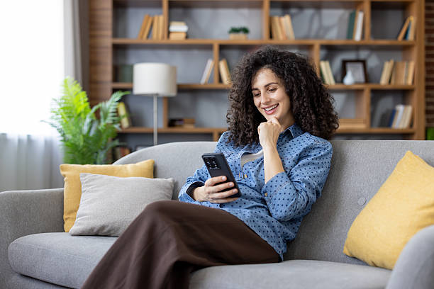 istock Woman relaxing on sofa using smartphone at home 2253463611