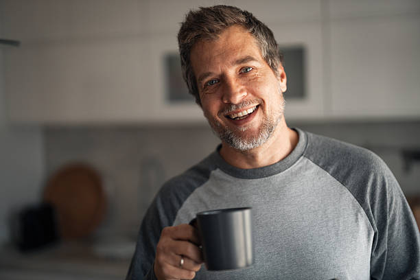 istock Smiling Man With Coffee Mug In Modern Kitchen Enjoying A Morning Moment 2253469238