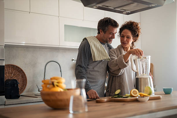 istock Couple In Modern Kitchen Preparing Smoothie Together With Fresh Fruit And Blender 2253469440