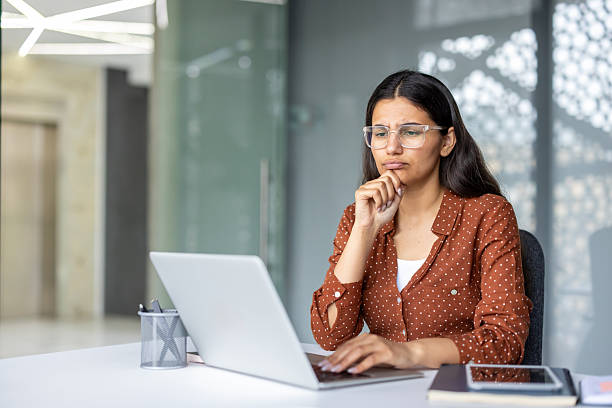 istock Young woman thinking deeply about business problem at office desk 2253469988