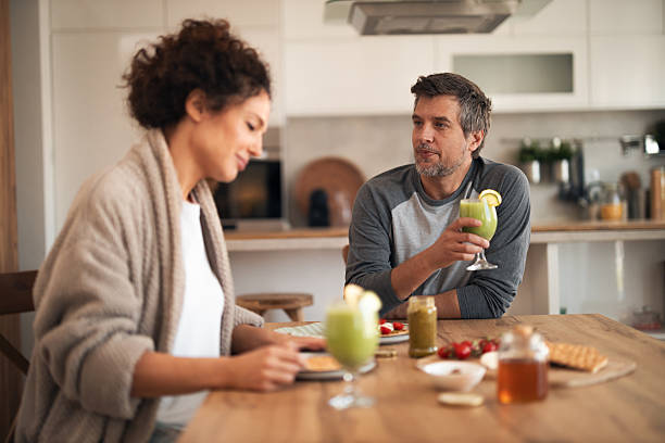 istock Casual Couple Enjoys Green Drinks At Kitchen Table During Cozy Breakfast Moment 2253470753