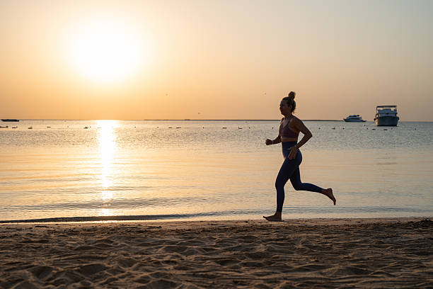 istock Young woman is running on sandy beach during peaceful sunset. 2253471578