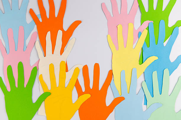 istock Interlocking paper hands of various colors on white background for Human Rights Day representing the strength of a united global community. 2253471775