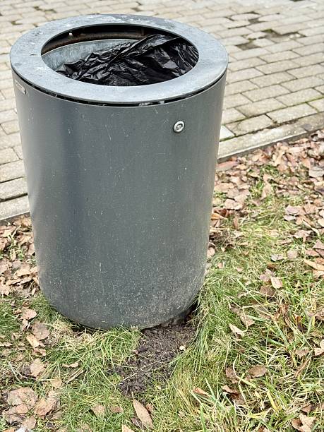 istock Waste Container Outdoors, Municipal Park Bin With Exposed Soil And Fallen Leaves Nearby, Outdoor Waste Container Situated On Grassy Terrain Amidst Seasonal Debris And Signs Of Erosion 2253472541