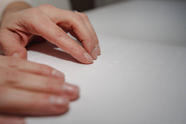 istock Person reading braille book with fingers 2253473098