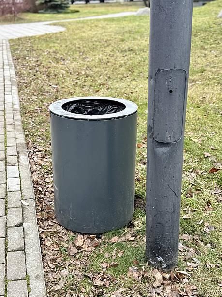 istock Waste Container Outdoors, Municipal Park Bin With Exposed Soil And Fallen Leaves Nearby, Outdoor Waste Container Situated On Grassy Terrain Amidst Seasonal Debris And Signs Of Erosion 2253473969