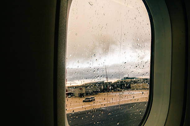 Aircraft Window with plane with rainy window and raindrops. High quality photo
