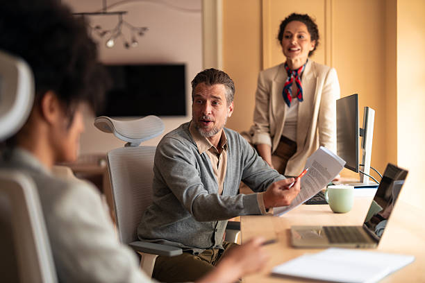 istock Team Meeting In Modern Office With Presenter Explaining Document To Colleagues 2253474826