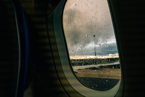 Aircraft Window with plane with rainy window and raindrops. High quality photo