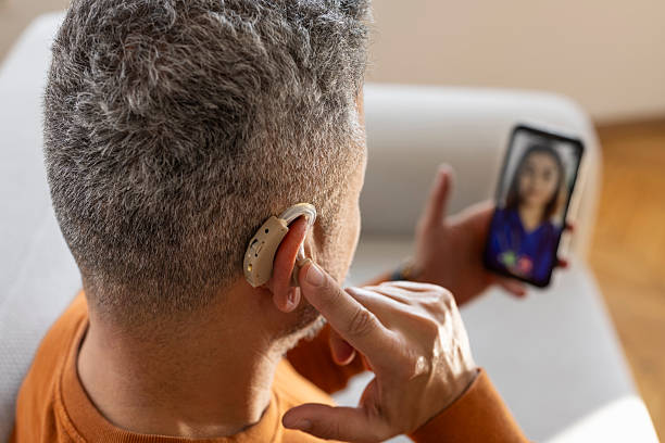 istock Man using hearing aid during online video consultation at home 2253475452