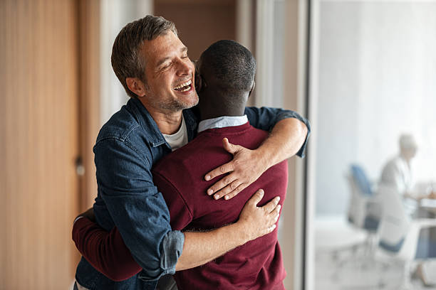 istock Joyful Hug Between Colleagues in Office, Warm Embrace and Friendship at Work 2253476250