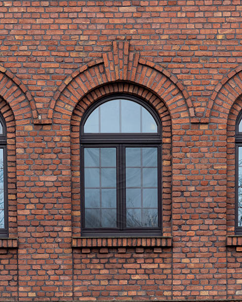 istock Historical brick wall with windows showcasing architectural design in an urban setting 2253478473
