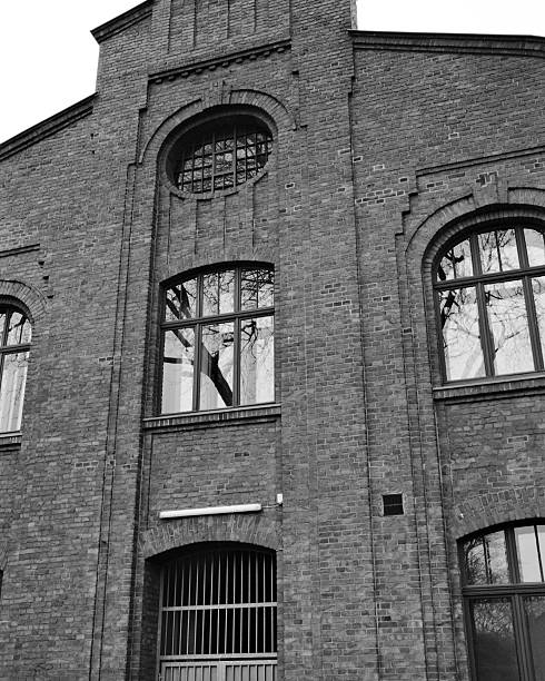 istock Historic brick building featuring tall arched windows and intricate architectural details in black and white 2253478512