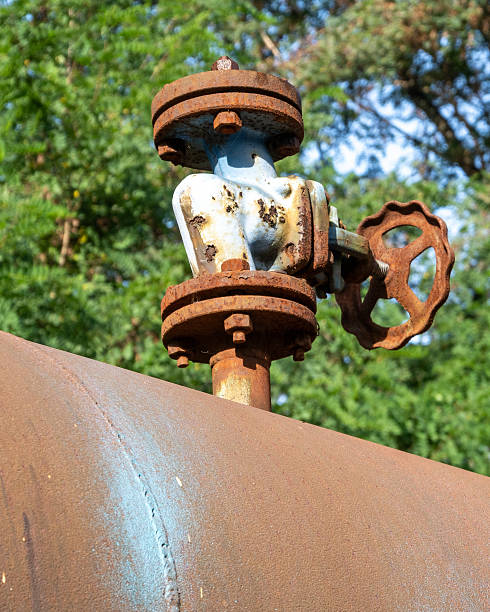 istock Rusty water valve on an old pipeline surrounded by trees during the daytime 2253478694