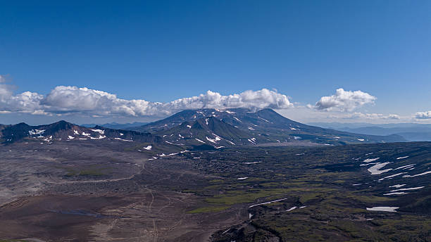 istock Mountainous landscape with snow capped peaks under a blue sky scattered with clouds 2253482513
