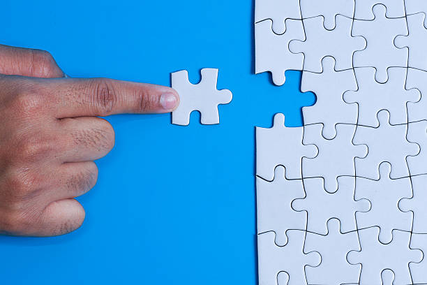 istock Merger and Integration Concept with Hand placing puzzle piece into gap on blue background 2253487369