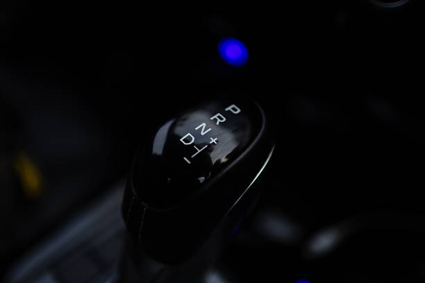 istock Modern Automatic Gear Shift Lever in Dark Interior,Close-up of a modern automatic transmission gear shift knob with P, R, N, D and manual mode indicators (+/-). 2253487676