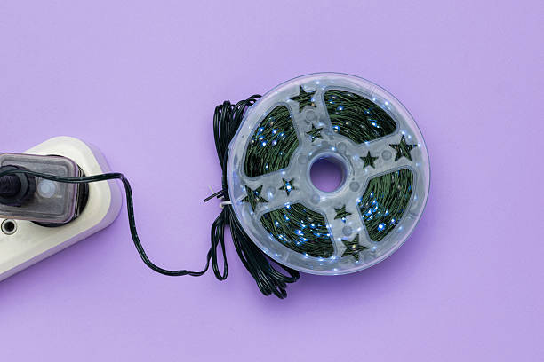 istock LED String Lights Rolled in Plastic Reel on Purple Background with Power Strip 2253487965