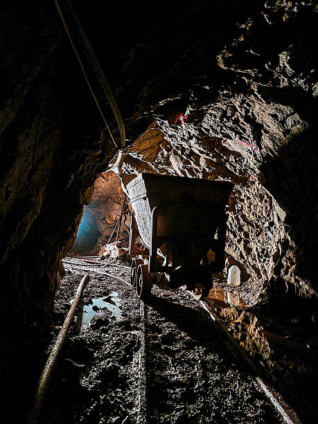 istock Mining cart on rails inside a dark underground tunnel 2253492251