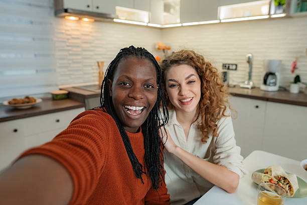 istock Diverse women friends smiling taking selfie in kitchen 2253492400