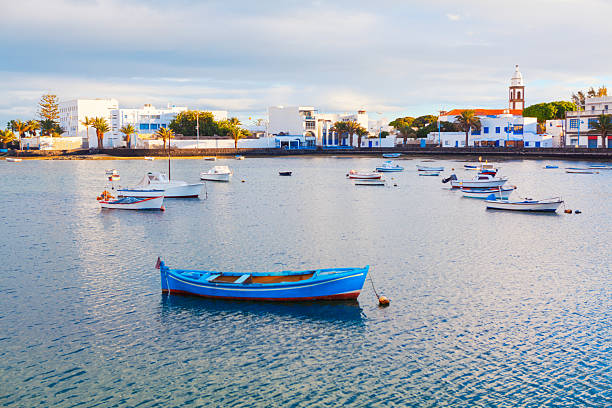 Charco de San Gines, lagoon and urban harbor in Arrecife, capital of Lanzarote in Canary Islands, Spain. Scenic area whit fishermen cottages and promenade with bars and restaurants, moored small boats