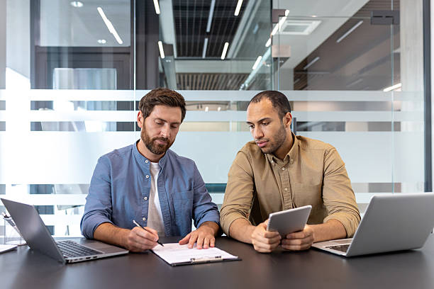 istock Two businessmen working together on a project in modern office 2253496395
